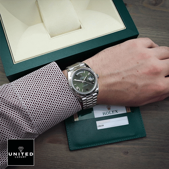 Rolex Day-Date 228239-0033 "Green Dial" Ultra Fine Replica rolex day date 228239 stainless steel green dial Rolex Day-Date Olive Green 228239 Replica Rolex Box in front of on is arm